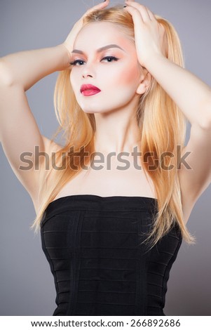 fashion close up portrait of beautiful young blond woman in black dress