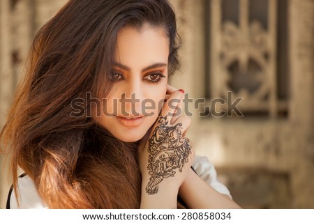 Portrait of a young indian woman in casual style with mehendi on the streets of old city