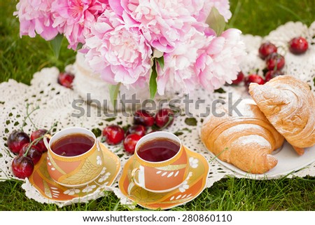 romantic breakfast in nature with fresh croissants and tea on a summer day