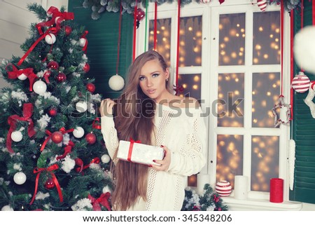Beauty fashion woman with Christmas gift box, new year tree background