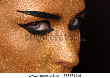 Golden Woman\'s Face Closeup. Futuristic Gilded Make-up. Painted Skin