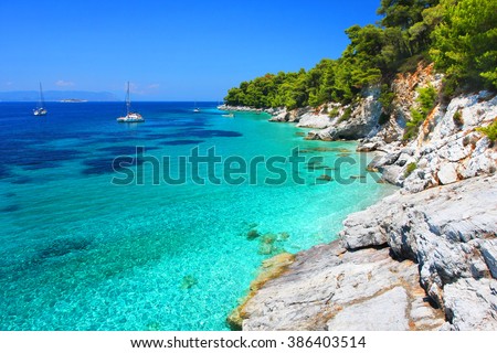 Turquoise waters with cliffs and anchoring sailboats in the neighborhood of Kastani beach (another filming location of Mamma Mia! musical), Skopelos island, Greece