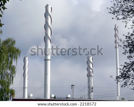Industrial chimneys and factory fumes against a cloudy sky