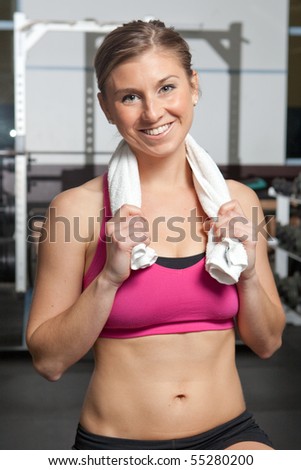 Attractive young woman in gym with white towel