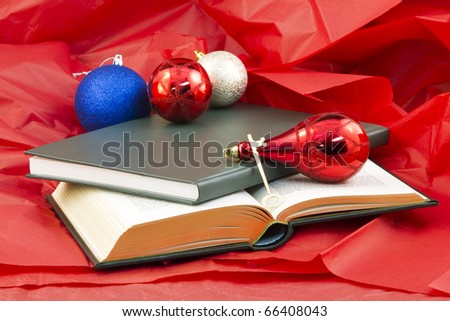 Golden key and open book and closed book on red paper with holiday ornaments reflect the gift that opens knowledge