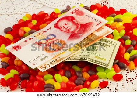 Three key world currencies placed on top of  jelly beans raises the question of where the global economy\'s sweet spot will be