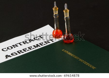Contract Agreement with two beakers and a laboratory notebook
