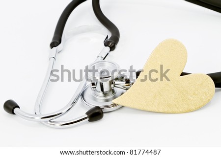 Medical stethoscope with gold heart on white background; closeup;