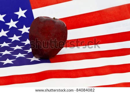 A red apple, symbol of teachers and schools, is placed on an American flag.