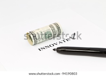 The word, innovate, is printed out with a black check next to it and rolled US currency above.  Black felt tip pen is on the right;