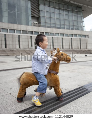 chinese boy ride electrical  donkey at playground