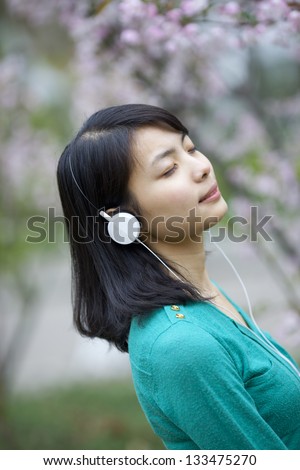 Asian Beautiful girl hearing music with pink flower