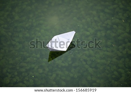 paper boat sailing in lake with peace