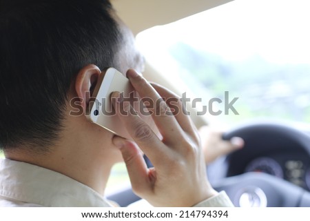 man pick up phone when driving-dangerous action