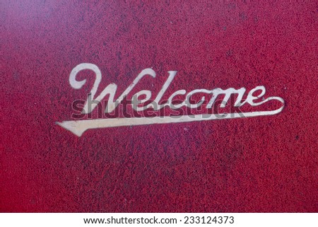 Red Welcome mat on the ground