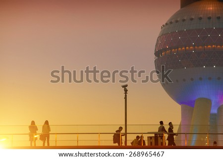 SHANGHAI, CHINA - March 29: Office people passing the Oriental Pearl Tower after getting off work on March 29, 2015 in Shanghai, China. More than 20K people working at this Shanghai finance  area.