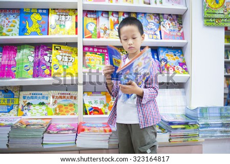 Shanghai,China-October 1,2015:Asian boy reading book at library,Shanghai