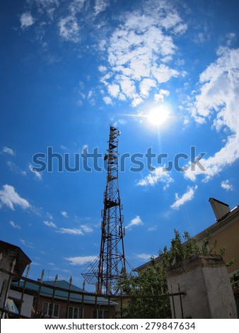 Tower of cellular communication against the blue sky and bright sun with wide angle fisheye lens and distortion view