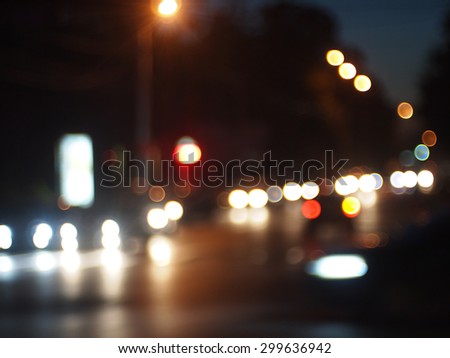 Blurred out of focus lights from cars, traffic lights and street lights in a night scene on the road was blurred for use as a background