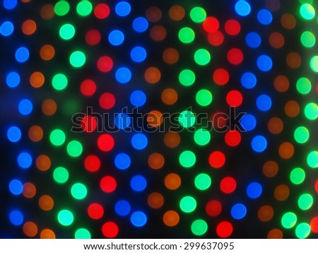 Defocused and blurry multicolored lights on a dark background in the form of circles in the correct order was blurred for use as a background