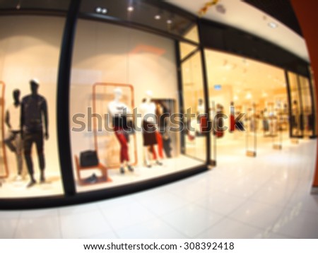Defocused and blur image of a large shopping mall hall with glass display cases and mannequins with wide angle fisheye lens and distortion view. The image was blurry for use as background
