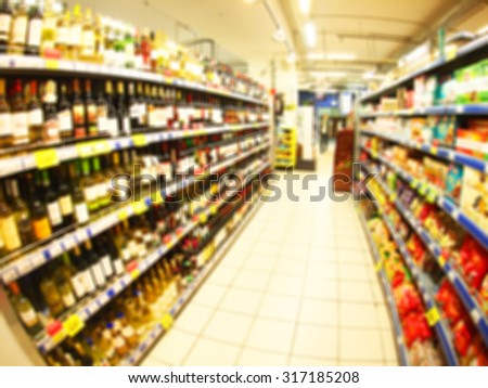 Blur and wide angle distortion view of the shop interior with shelves on which stand the bottle with alcohol and foods. Image was defocused for use as background
