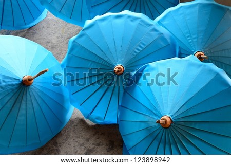 Thailand, Chiang Mai, hand painted Thai umbrellas drying in the sun outside an umbrella factory