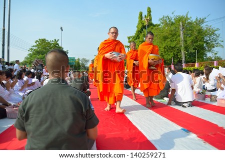 BANGKOK, THAILAND - MAY 23: People give food offerings to Buddhist monks on May 23, 2013 in Bangkok, Thailand. Thai tradition