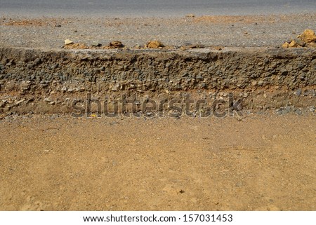 Damaged asphalt. Layer of clay that were eroded under the asphalt.