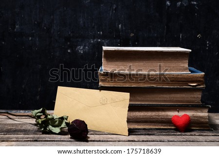 Old book, letters and rose on wooden background