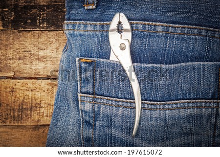 Several tools on a denim workers pocket