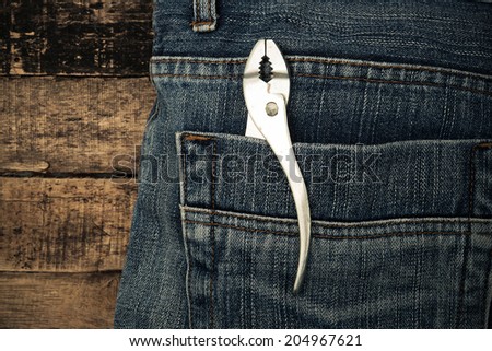 Several tools on a denim workers pocket