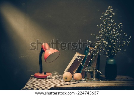 Vintage still life with old spectacles on book near desk lamp