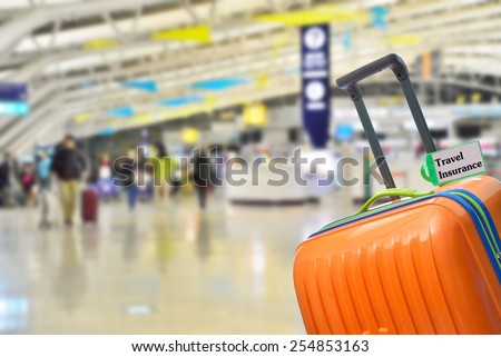 Travel Insurance. Blue suitcase with label at airport.