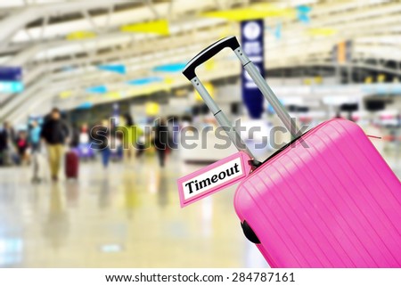 timeout. suitcase with label at airport.