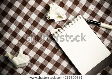 note book paper on old wooden background.