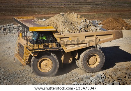 Large yellow truck used in modern Mine in Western Australia. Truck transports ore from the open cast mine.