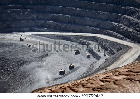 Large trucks being filled with ore at the bottom of an open cast mine. Barrick Cowal Gold Mine in New South Wales, Australia.