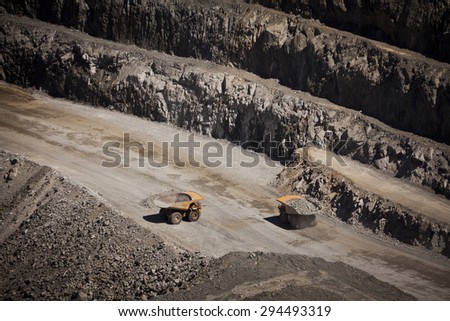 Yellow trucks inside an open cast mine in New South Wales, Australia. Barrick Cowal Gold Mine.