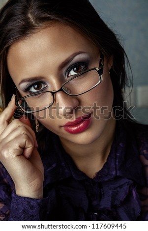 Portrait of business woman in glasses. A look through the glasses