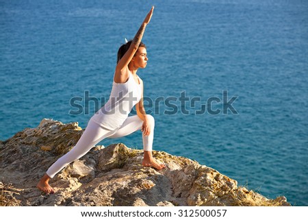 Meditation young  yoga woman meditating at sea beach relaxing in yoga pose. Yoga girl relaxed doing exercises on background of nature sea scene on mountains.