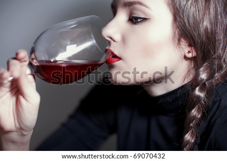 Young beautiful girl testing  red wine