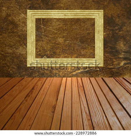 Grunge abstract background with golden picture frame on wall and wooden plank floor.