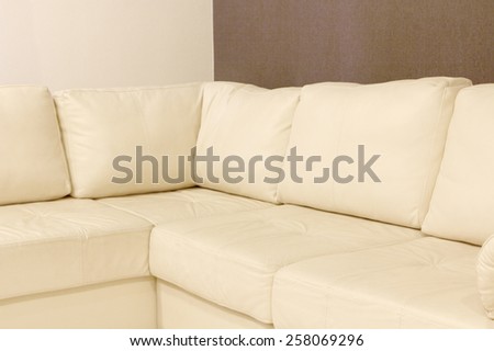 Modern white corner leather sofa taken closeup.