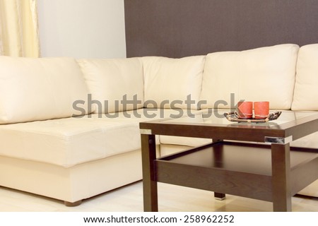 Interior with white corner leather sofa and coffee table.