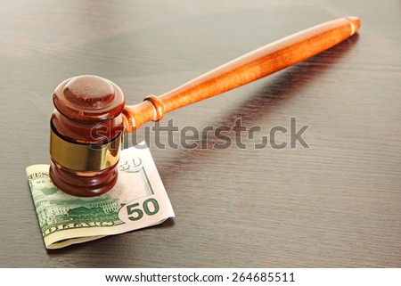 Judge gavel and fifty dollars on wooden table taken closeup.