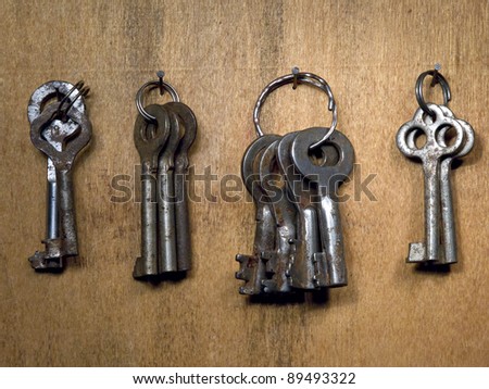 A lot rusty old keys on a wooden wall.