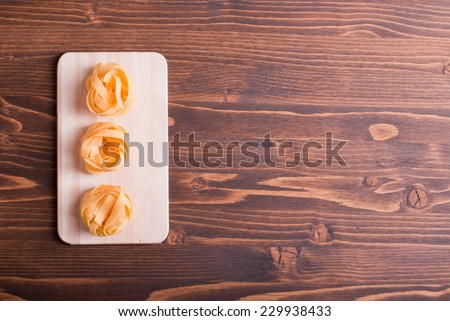 pasta raw three circles in a row on a small light on a cutting board korrichenvom table top view on the right place for text