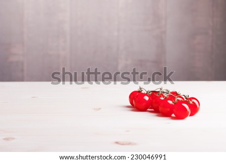 cherry tomatoes on a light wooden table side view