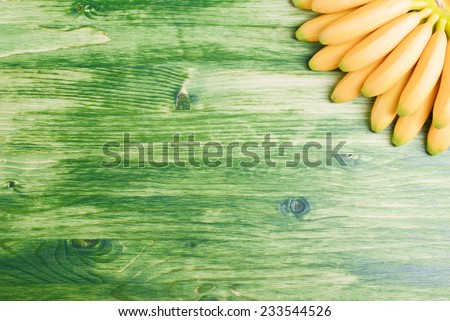 yellow bananas baby down with his fan on green board in the top right corner of the left space for text